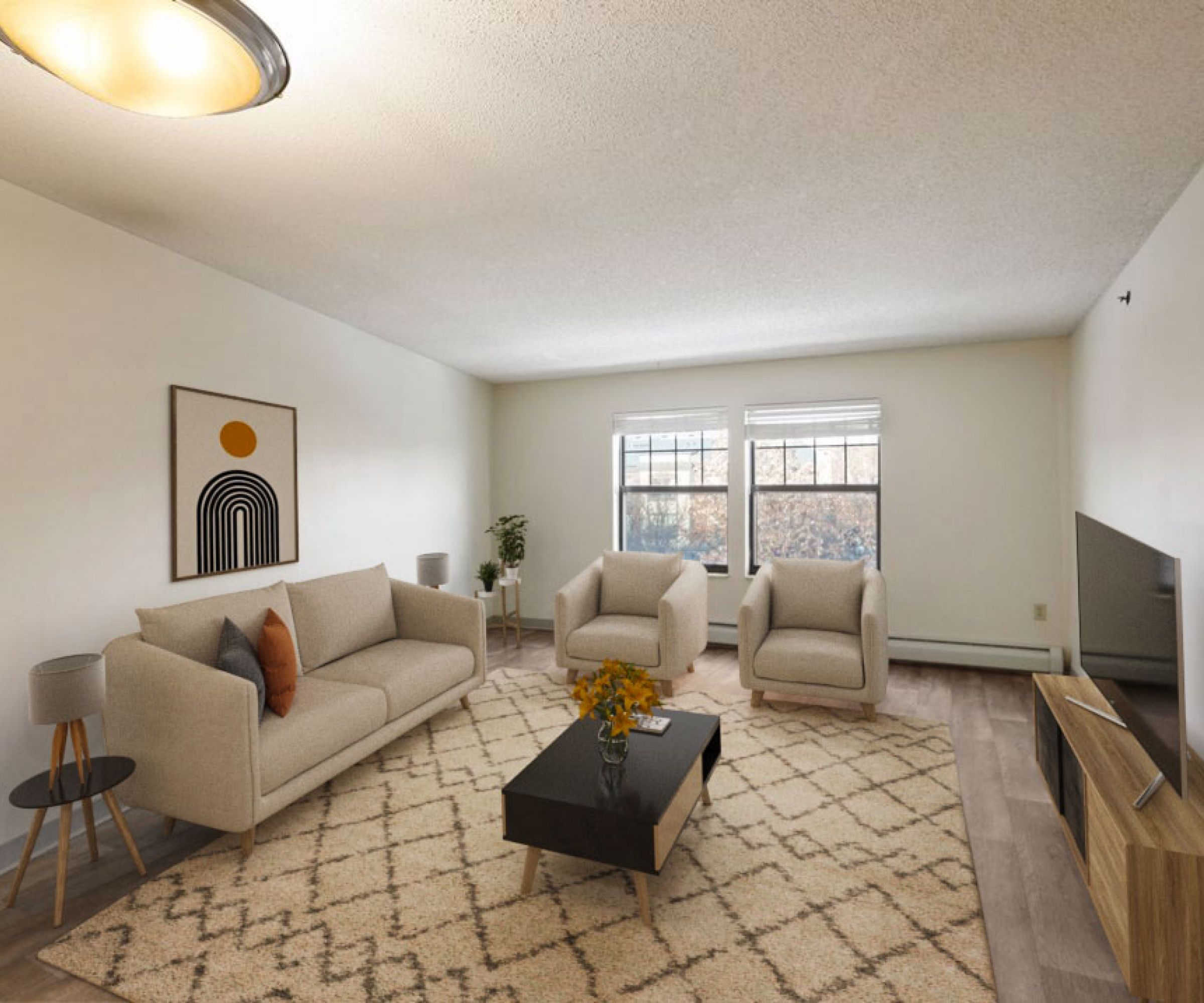 Aeon Affordable Homes and Community A cozy living room in affordable apartment homes with a beige sofa, chairs, patterned rug, TV, and wall art, all lit by a ceiling light.