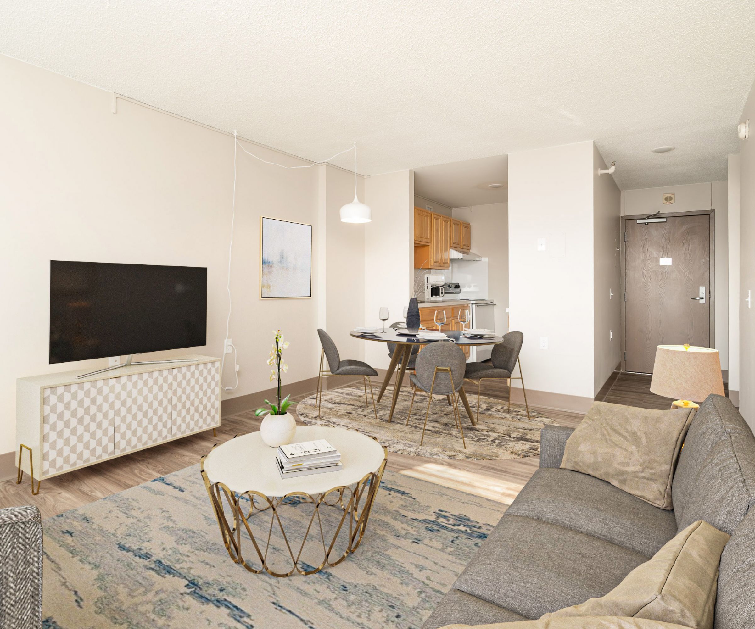 Aeon Affordable Homes and Community Affordable apartment homes featuring a modern living room with a gray sofa, TV, round coffee table, dining area, and kitchen in neutral tones.