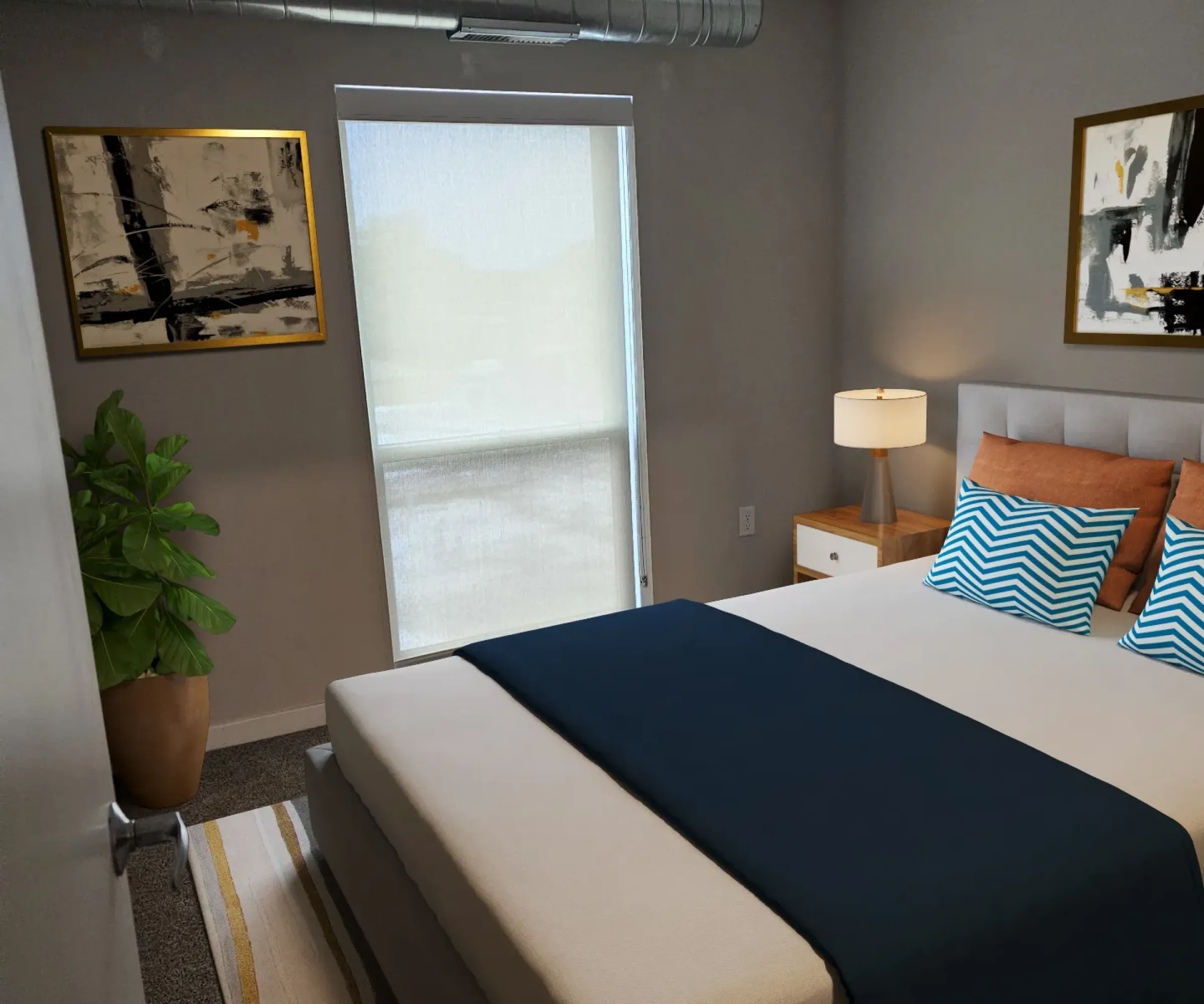 Aeon Affordable Homes and Community Modern bedroom in affordable apartment homes, featuring a large bed, abstract art, a plant, and window light on the floor.