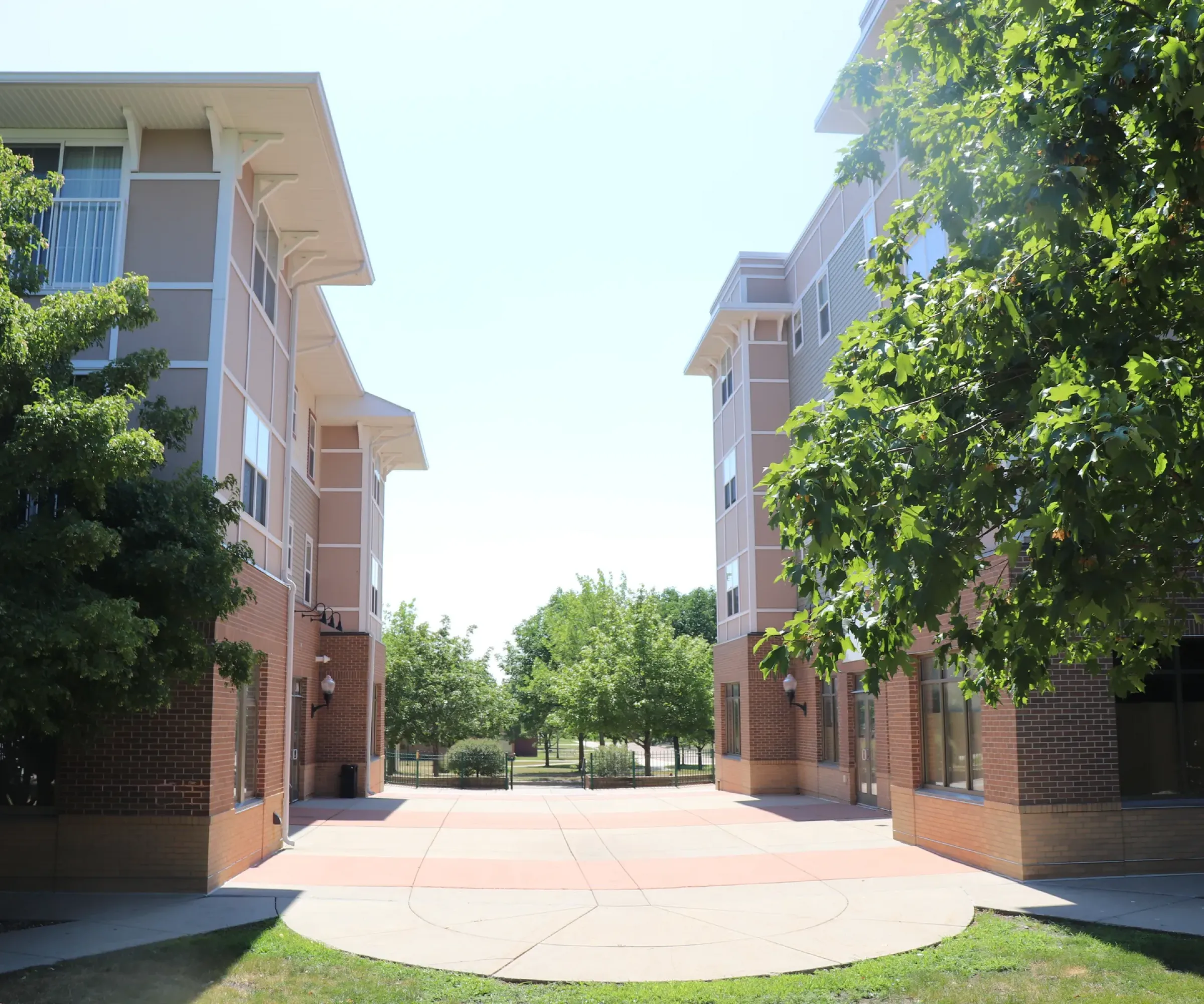 Aeon Affordable Homes and Community A sunny courtyard between modern brick buildings offers a peaceful escape for residents of our affordable apartment homes.