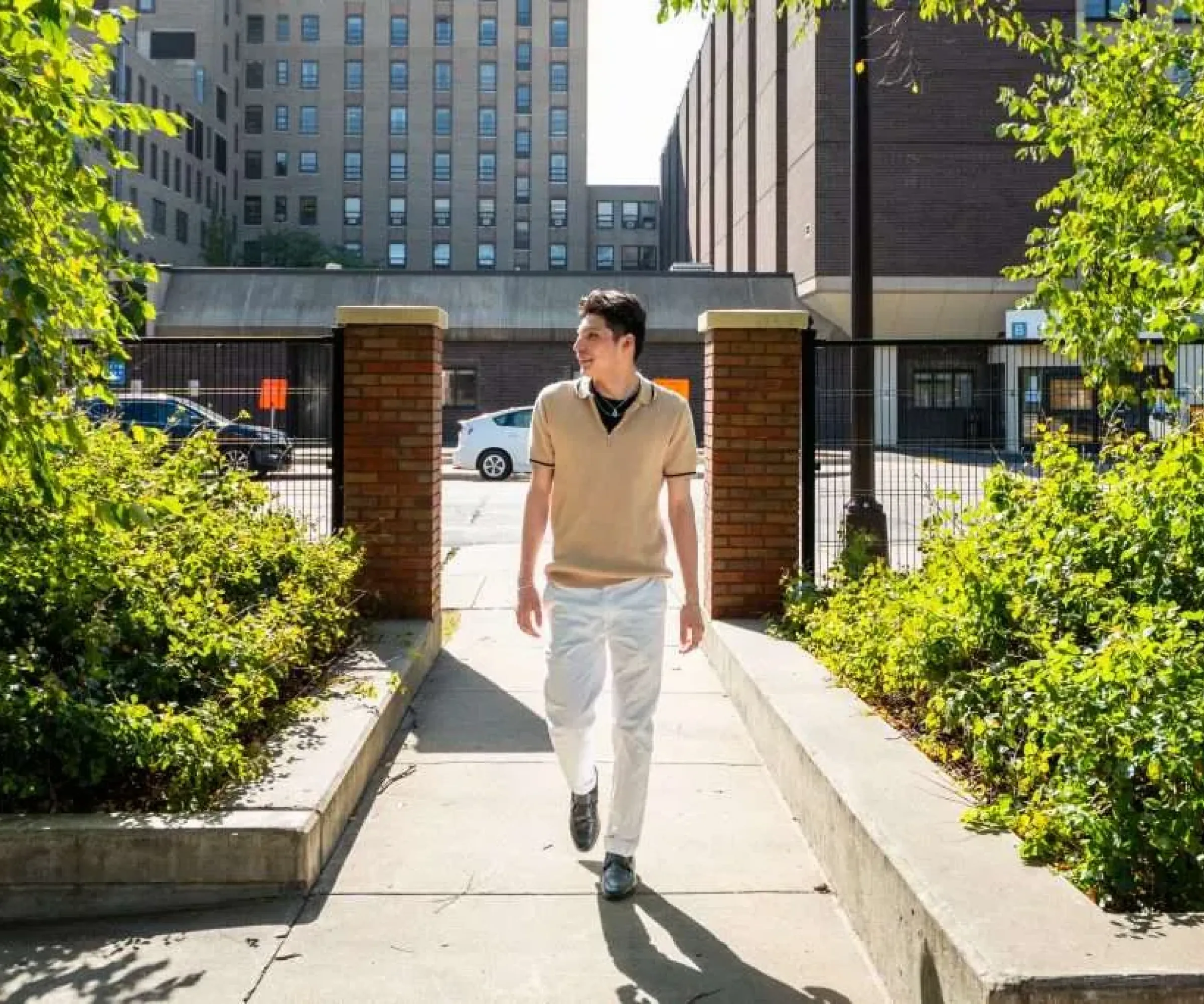 Aeon Affordable Homes resident, Z, walks along a paved pathway at an Aeon community