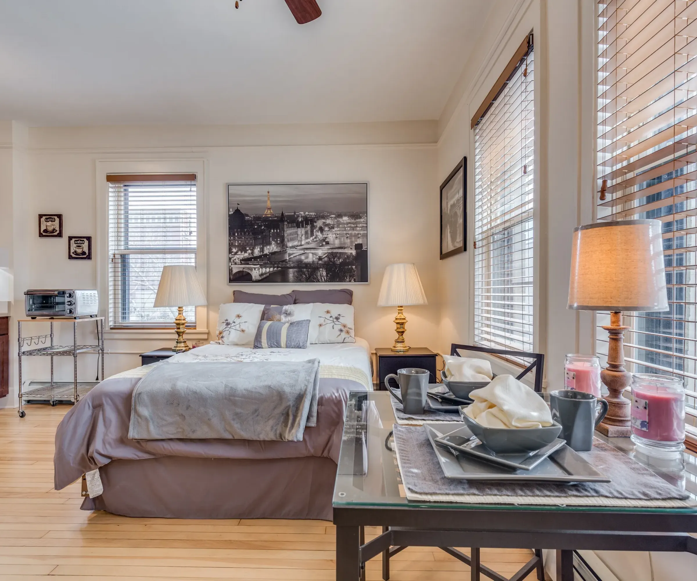 Aeon Affordable Homes and Community Cozy, affordable studio apartment with bed, dining table, and kitchenette. Soft lighting and decor create a warm ambiance.