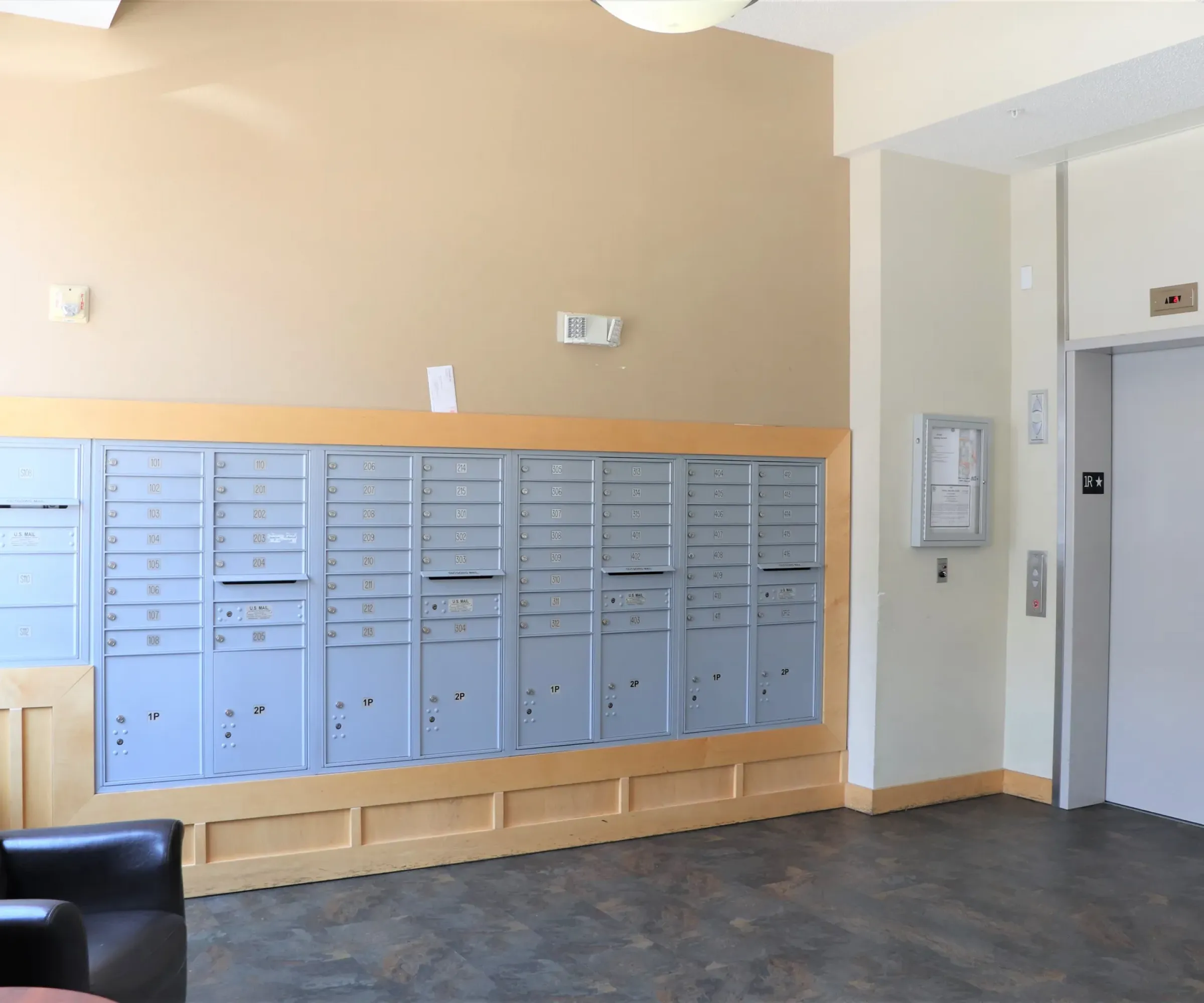 Aeon Affordable Homes and Community A lobby with mailboxes on the wall and an elevator door on the right, welcoming you to your affordable apartment home.