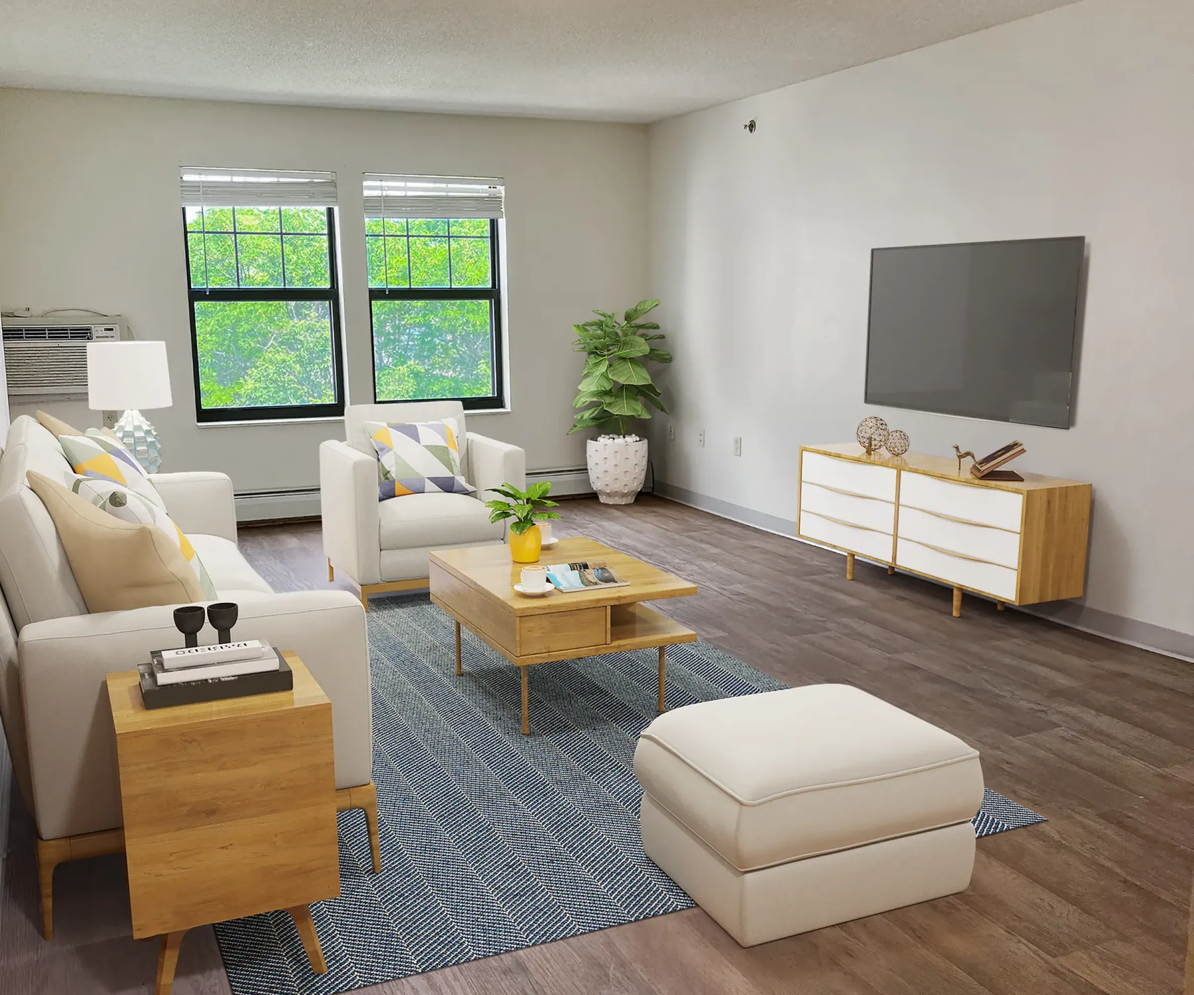 Aeon Affordable Homes and Community Modern living room with beige sofas, a wooden coffee table, a flat-screen TV, and large windows in affordable apartment homes overlooking greenery.