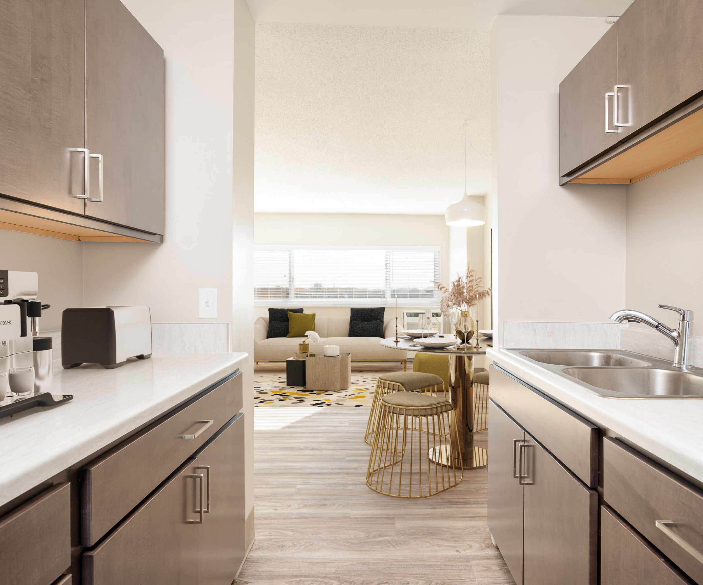 Aeon Affordable Homes and Community Modern kitchen with wooden cabinets, coffee maker, and view of a bright living room in affordable apartment homes.