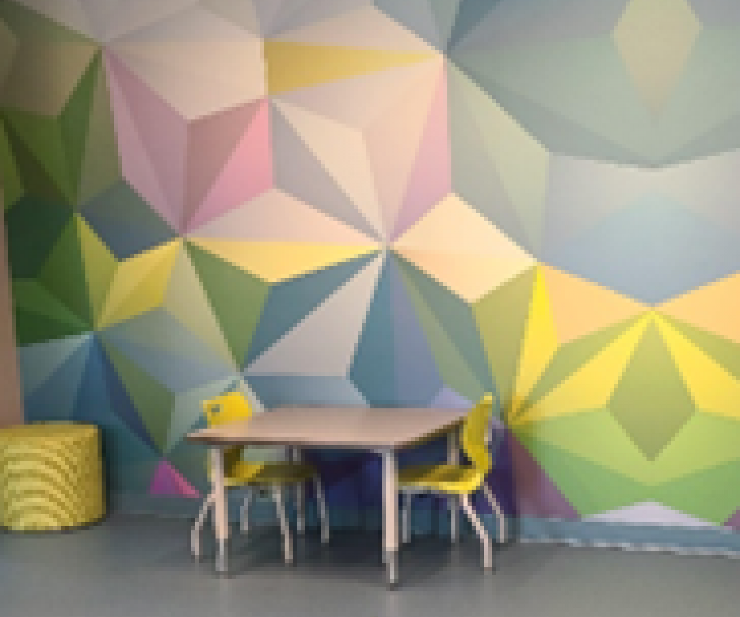 Aeon Affordable Homes and Community Affordable apartment homes featuring a room with a geometric mural, small table, two yellow chairs, and a cozy yellow pouf.
