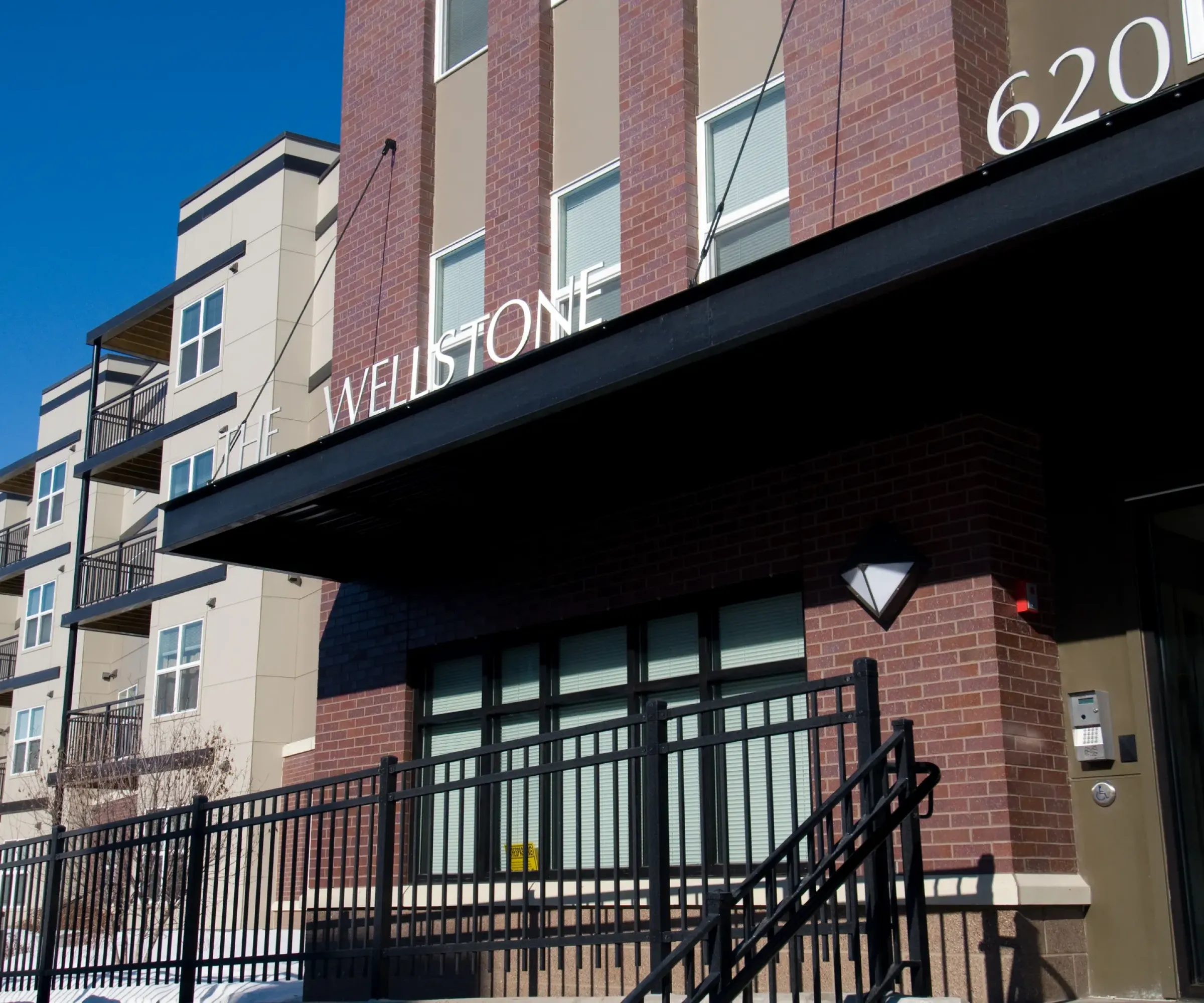 Aeon Affordable Homes and Community Entrance to modern, affordable apartment homes with "Wellstone" and "620" on the facade.