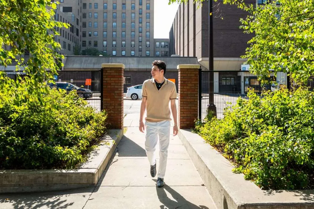 Aeon Affordable Homes resident, Z, walks along a paved pathway at an Aeon community