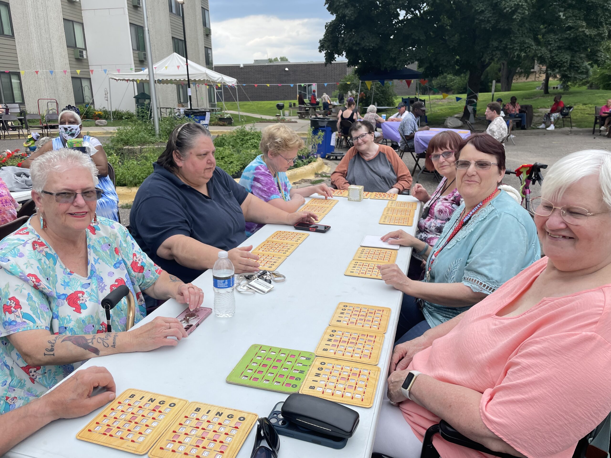 Aeon Affordable Homes Neighbors gather at a table playing bingo during a lively community event.